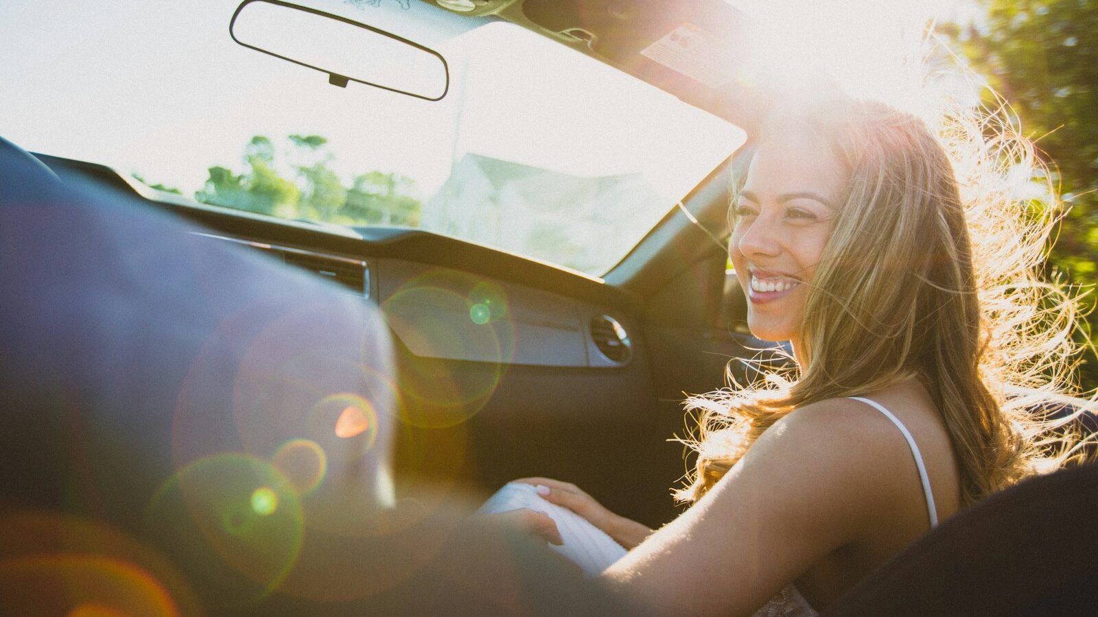 smiling woman sitting inside the vehicle at daytime